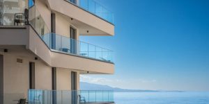 Modern white apartment building with blue sky and sea background. Beautiful modern architecture of the building. Architecture detail Modern facade building with balconies and windows